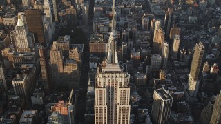 AX90_088 - 4K aerial stock footage Approaching top of Empire State Building, Midtown Manhattan, New York, sunrise