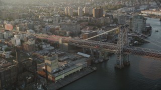 AX90_096 - 4K aerial stock footage Flying by Williamsburg Bridge, East River, New York, New York, sunrise