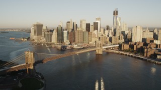 AX90_101 - 4K stock footage aerial video Flying by Brooklyn Bridge, Lower Manhattan skyline, New York, New York, sunrise