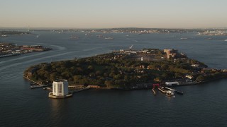 AX90_106 - 4K aerial stock footage Approaching Governors Island, New York, New York, sunrise