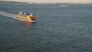 AX90_128 - 4K aerial stock footage Flying by Staten Island Ferry on New York Harbor, New York, New York, sunrise