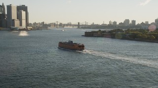 AX90_131 - 4K aerial stock footage Tracking the Staten Island Ferry near Lower Manhattan, New York, sunrise