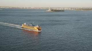 AX90_133 - 4K aerial stock footage Flying by Staten Island Ferry on New York Harbor, New York, New York, sunrise