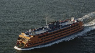 AX90_135 - 4K aerial stock footage Tracking the Staten Island Ferry sailing New York Harbor, New York, sunrise