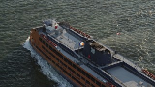 AX90_136 - 4K aerial stock footage Tracking the Staten Island Ferry cruising New York Harbor, New York, sunrise