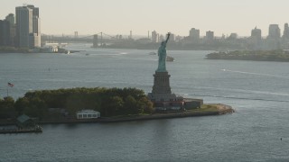 AX90_145 - 4K aerial stock footage Flying by Statue of Liberty, Liberty Island, New York, New York, sunrise