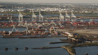 AX90_153 - 4K aerial stock footage Approaching cargo cranes, containers, Port Jersey, New Jersey, sunrise
