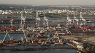 AX90_154 - 4K aerial stock footage Approaching cargo cranes, containers ,Port Jersey, New Jersey, sunrise