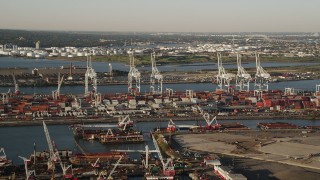 AX90_155 - 4K aerial stock footage Approaching cargo cranes, containers, Port Jersey, New Jersey, sunrise