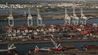 AX90_156 - 4K aerial stock footage Approaching cargo cranes, containers, Port Jersey, New Jersey, sunrise