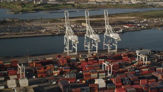 AX90_157 - 4K aerial stock footage Approaching cargo cranes, Port Jersey, New Jersey, sunrise