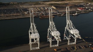 AX90_158 - 4K aerial stock footage Approaching cargo cranes, tilt down, Port Jersey, New Jersey, sunrise