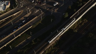 AX90_160 - 4K aerial stock footage Tracking a commuter train, Jersey City, New Jersey, sunrise