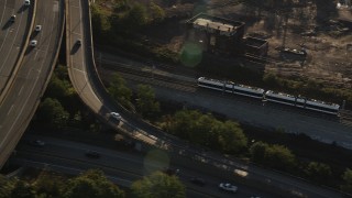 AX90_161 - 4K aerial stock footage Tracking a commuter train, Jersey City, New Jersey, sunrise