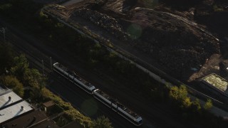 AX90_162 - 4K aerial stock footage Tracking a commuter train, Jersey City, New Jersey, sunrise