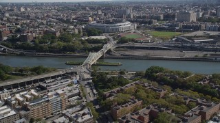 AX91_017 - 4K stock footage aerial video tilt from Harlem apartment buildings, reveal Macombs Dam Bridge and Yankee Stadium in The Bronx, New York