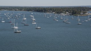 AX91_040 - 4K aerial stock footage of tilting from the ocean to reveal sailboats near the coast, Rye, New York