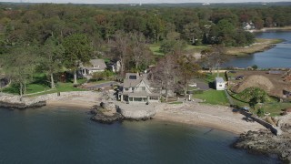 AX91_045 - 4K aerial stock footage of flying by a spacious oceanside mansion, Rye, New York