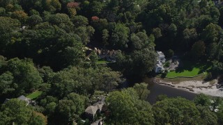 AX91_085 - 4K aerial stock footage tilt to mansions nearly hidden by trees in Darien, Connecticut