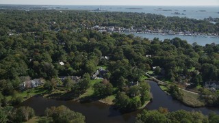AX91_089 - 4K aerial stock footage of flying over riverfront mansions and trees toward Five Mile River, Norwalk, Connecticut
