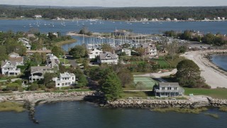 AX91_102 - 4K aerial stock footage of flying by beachfront homes and marina in Westport, Connecticut