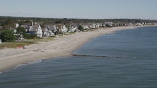AX91_112 - 4K aerial stock footage of flying by a row of homes lining a beach in Fairfield, Connecticut