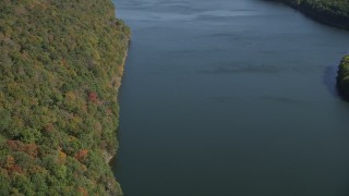 AX91_142 - 4K aerial stock footage pan from lake to forest with fall foliage, Lake Saltonstall, Connecticut