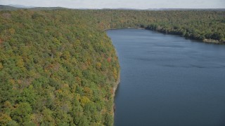 AX91_145 - 4K aerial stock footage of flying over forests in autumn and Lake Saltonstall, Connecticut