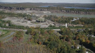 AX91_156 - 4K aerial stock footage of flying over fall foliage, approaching quarry, North Branford, Connecticut