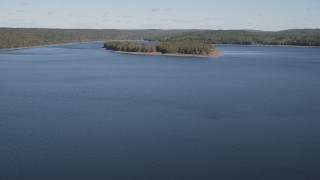AX91_157 - 4K aerial stock footage of flying over Lake Gallard, revealing small island in autumn, Lake Gallard, Connecticut