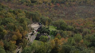 AX91_171 - 4K aerial stock footage of flying over forest, revealing homes in autumn, Guilford, Connecticut