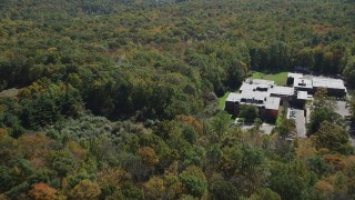 AX91_174 - 4K aerial stock footage flyby Abraham Baldwin Middle School and over forest, autumn, Guilford, Connecticut