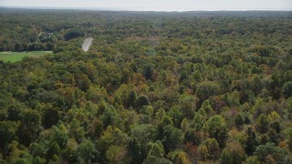AX91_175 - 4K aerial stock footage of panning and flying over lush forest, autumn, Guilford, Connecticut