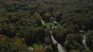 AX91_178 - 4K aerial stock footage of flying over forest, road and homes in autumn, Guilford, Connecticut