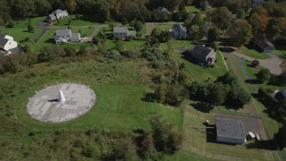 AX91_180 - 4K aerial stock footage of flying over forest, and by sundial and houses in autumn, Guilford, Connecticut