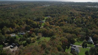 AX91_182 - 4K aerial stock footage of flying over suburban neighborhoods and forests in autumn, Guilford, Connecticut