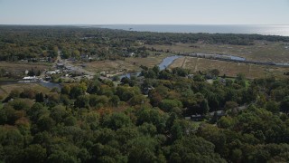 AX91_187 - 4K aerial stock footage of flying over rural neighborhoods while approaching a river in autumn, Guilford, Connecticut
