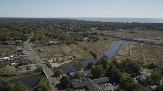 AX91_188 - 4K aerial stock footage of flying over a river and approaching rural homes in autumn, Guilford, Connecticut