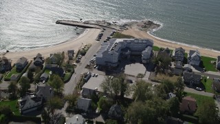 AX91_191 - 4K aerial stock footage of flying by a beachfront hotel and homes in Madison, Connecticut