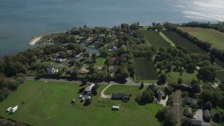 AX91_197 - 4K aerial stock footage of approaching waterfront homes and vineyard in Southold, New York