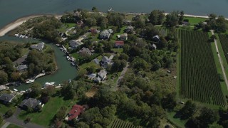 AX91_198 - 4K aerial stock footage of flying by waterfront homes and a vineyard, Southold, New York