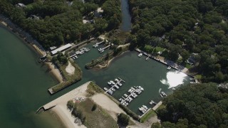 AX91_200 - 4K aerial stock footage of flying over a small marina beside a beach in Southold, New York