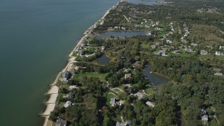 AX91_203 - 4K aerial stock footage of flying by upscale homes in a coastal neighborhood, Southold, New York