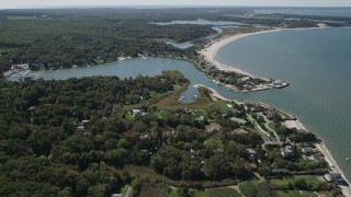 AX91_205 - 4K aerial stock footage approach Wooley Pond, tilt to upscale beachfront homes, Southampton, New York
