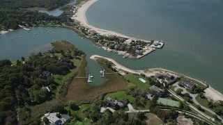 AX91_206 - 4K aerial stock footage of flying by beachfront homes by Wooley Pond, Southampton, New York