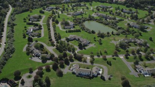 AX91_209 - 4K aerial stock footage of flying over upscale homes near a small pond in Southampton, New York