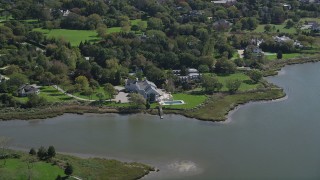 AX91_211 - 4K aerial stock footage of flying by a waterfront mansion in Southampton, New York