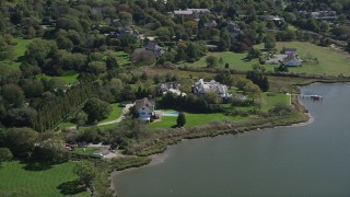 AX91_212 - 4K aerial stock footage of passing by waterfront mansions, Southampton, New York
