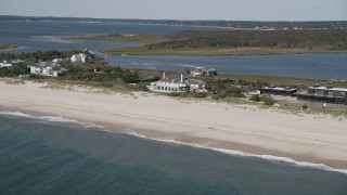 AX91_218 - 4K aerial stock footage of flying by a beachfront mansion in Southampton, New York
