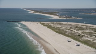 AX91_230 - 4K aerial stock footage fly over RVs on a beach to approach Shinnecock Inlet, Southampton, New York